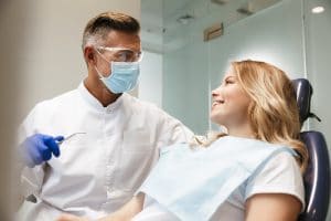 Image of a beautiful happy young woman sitting in medical dentist center.